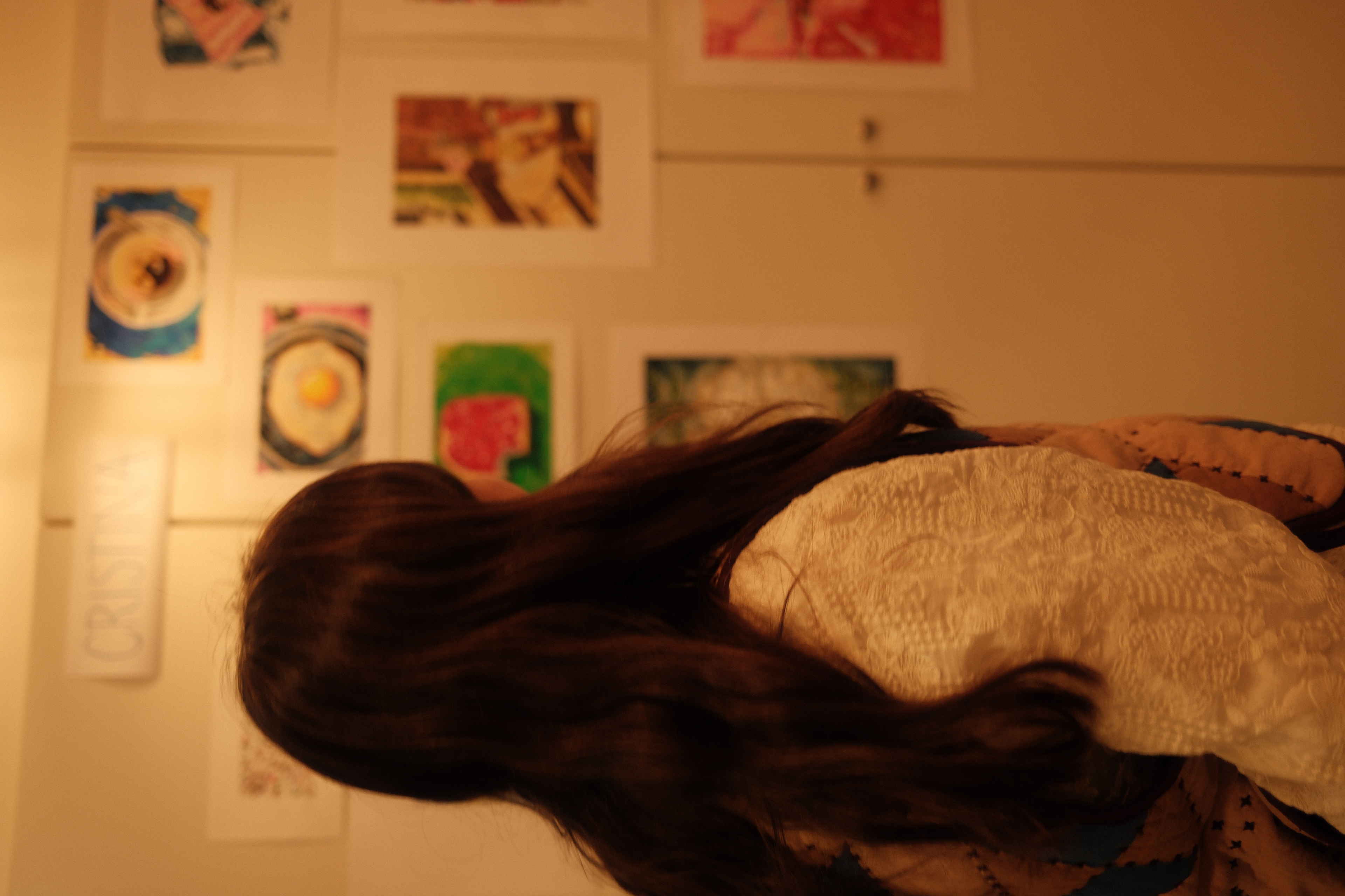 Cris Jara in her studio, looking at her paintings